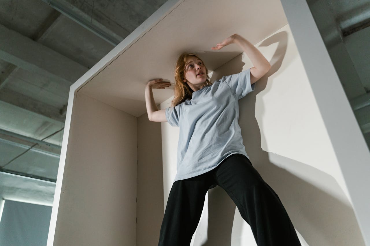 A woman appearing anxious inside a tight space, expressing feelings of claustrophobia and stress.